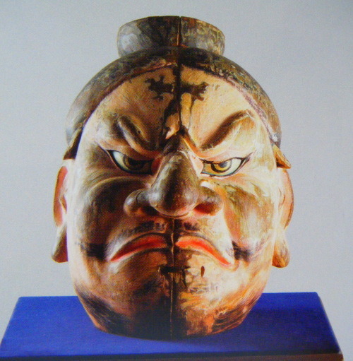 Ce masque est sensé représenter le chef emishi Aterui. Traits grossiers et déformés, barbe, il est une incarnation du barbare.